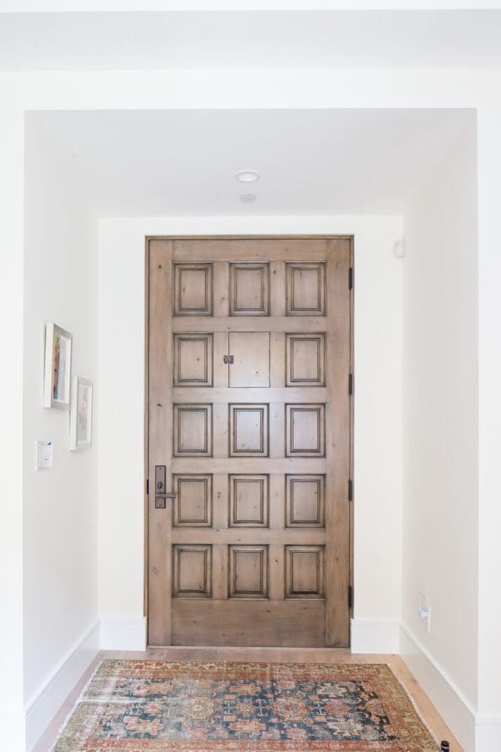 Wooden paneled front door in bright entryway