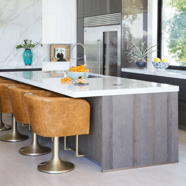 Modern kitchen with island and leather chairs.