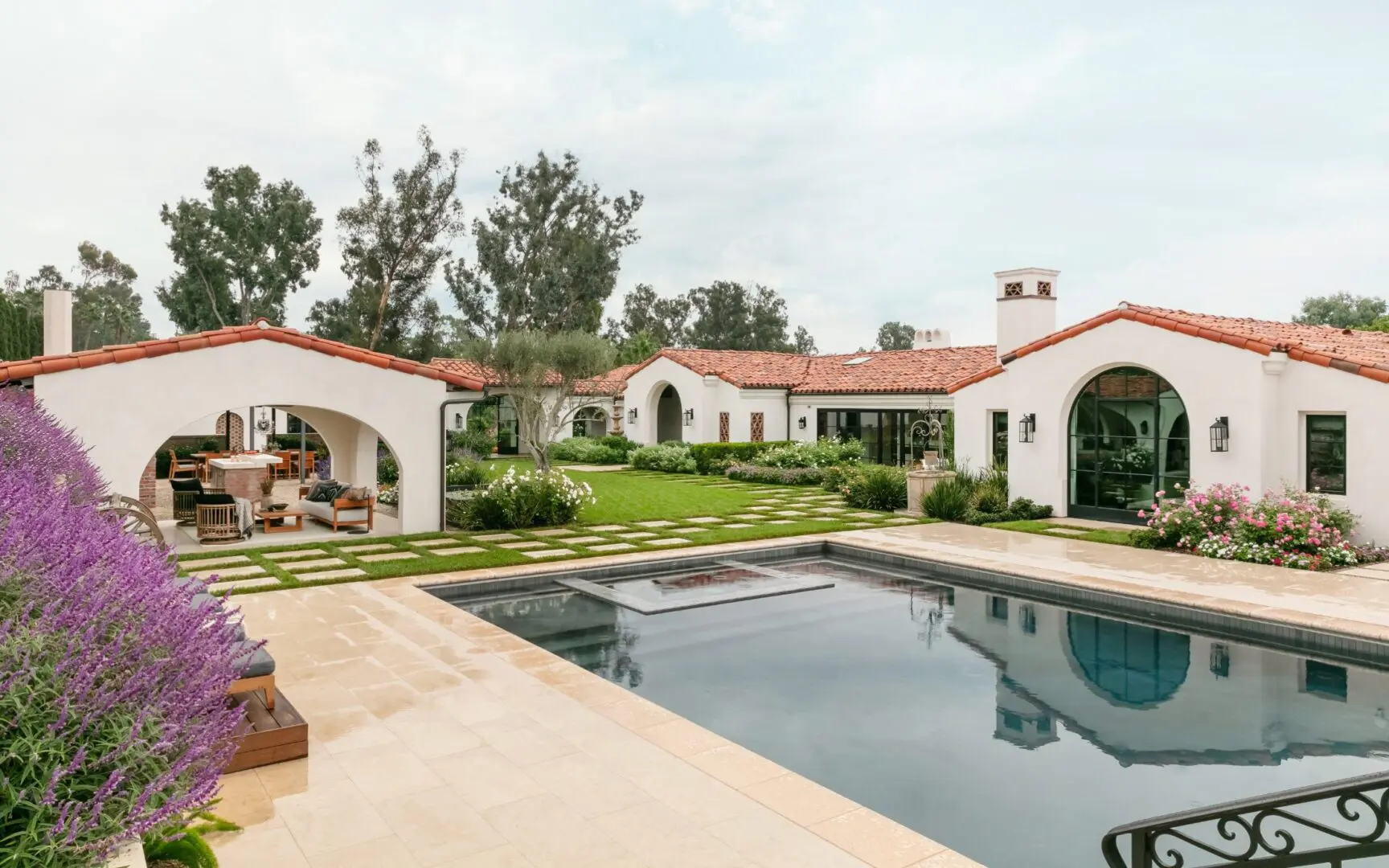Pool and gardens in the yard of a Spanish-style estate.