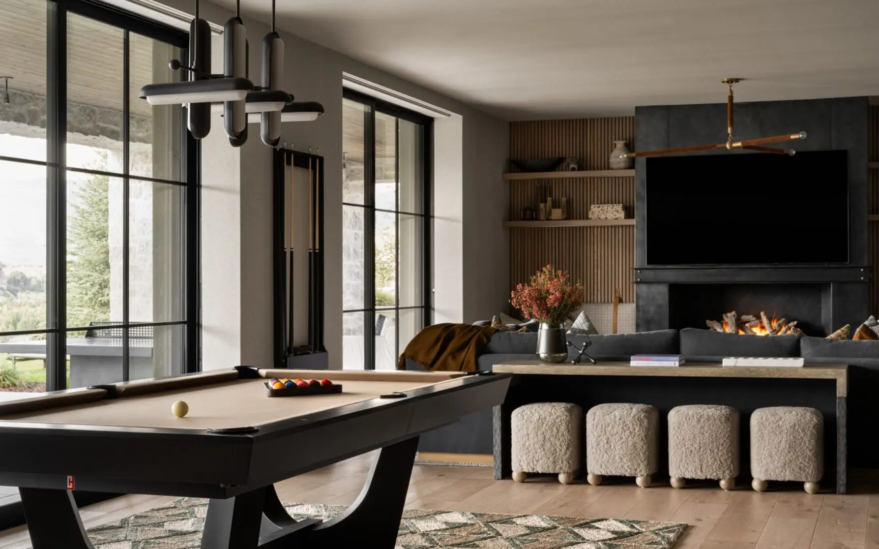 Mountain home game room with pool table and modern light fixtures.