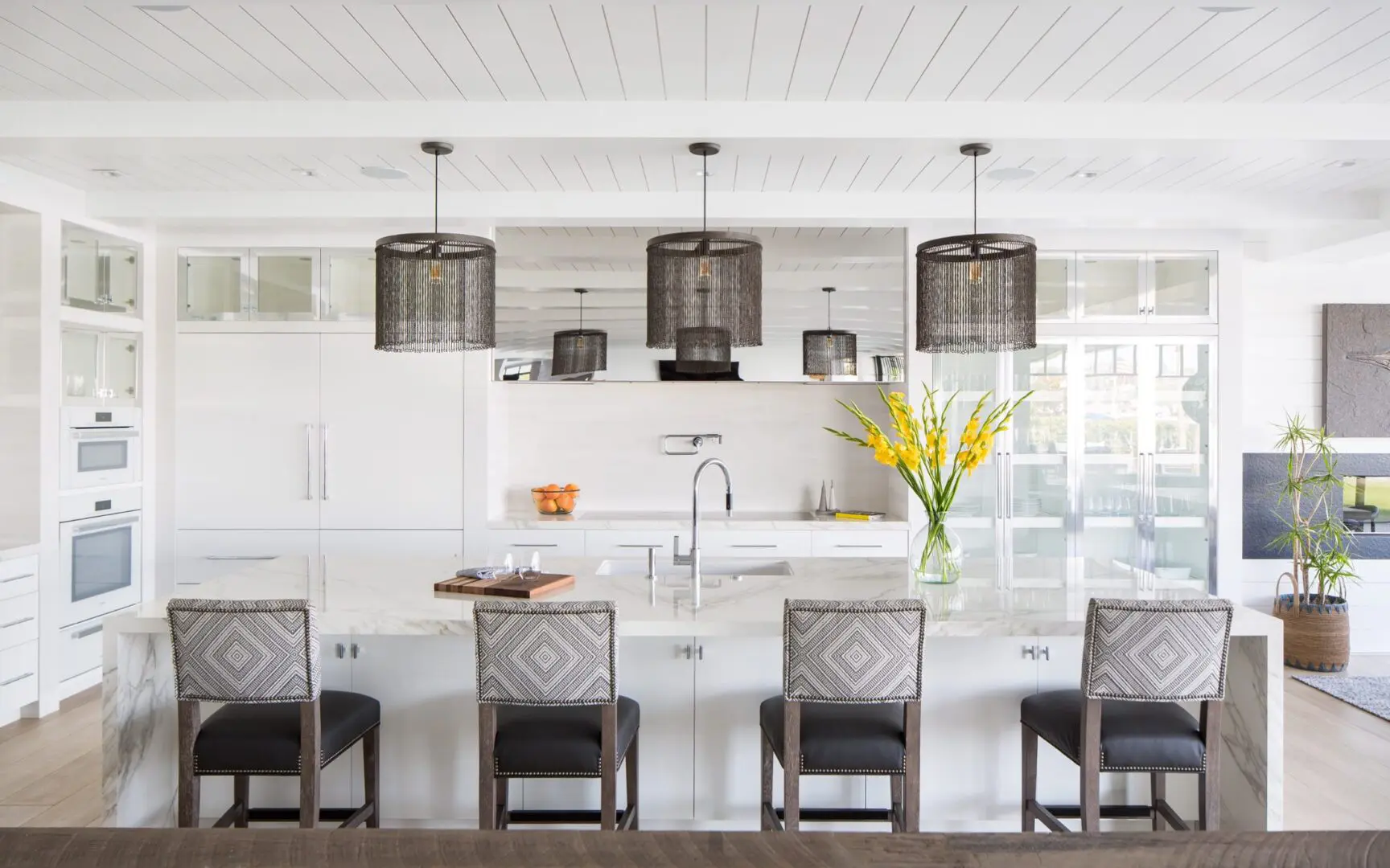 Luxury kitchen with white lacquered cabinets and chainlink pendants.