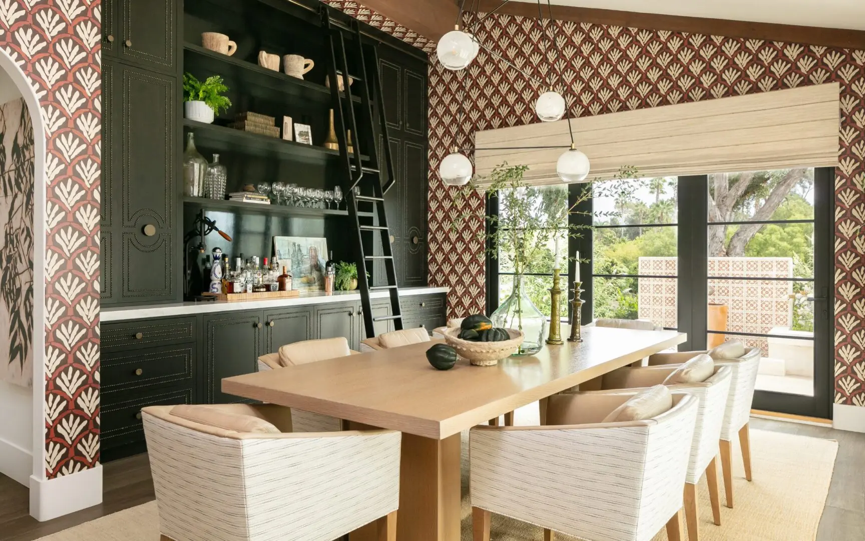 High-end dining room with patterned wallpaper and custom cabinetry.