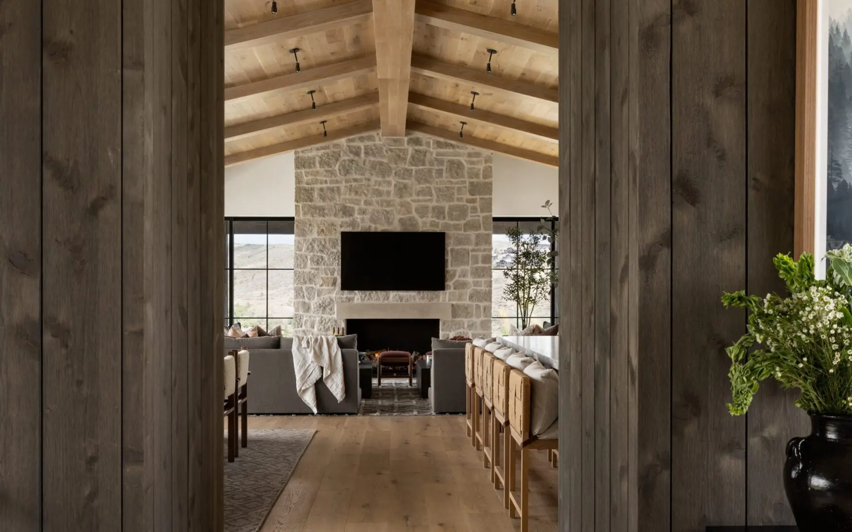 Luxury mountain home with wood wall paneling and a stone fireplace.