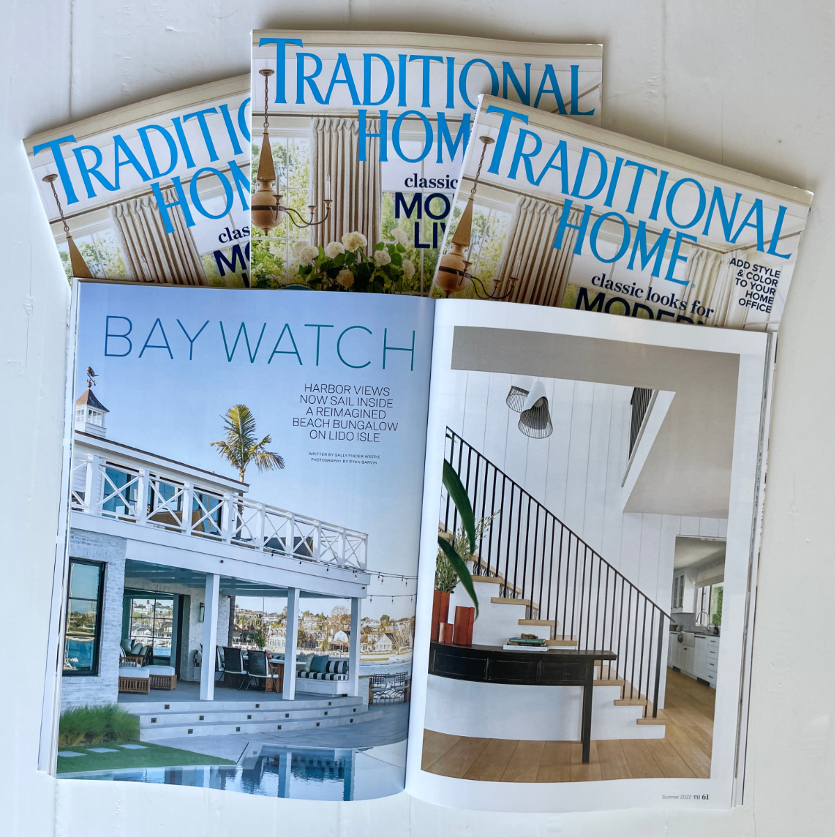 Magazines sprawled out showing a beautiful coastal home.