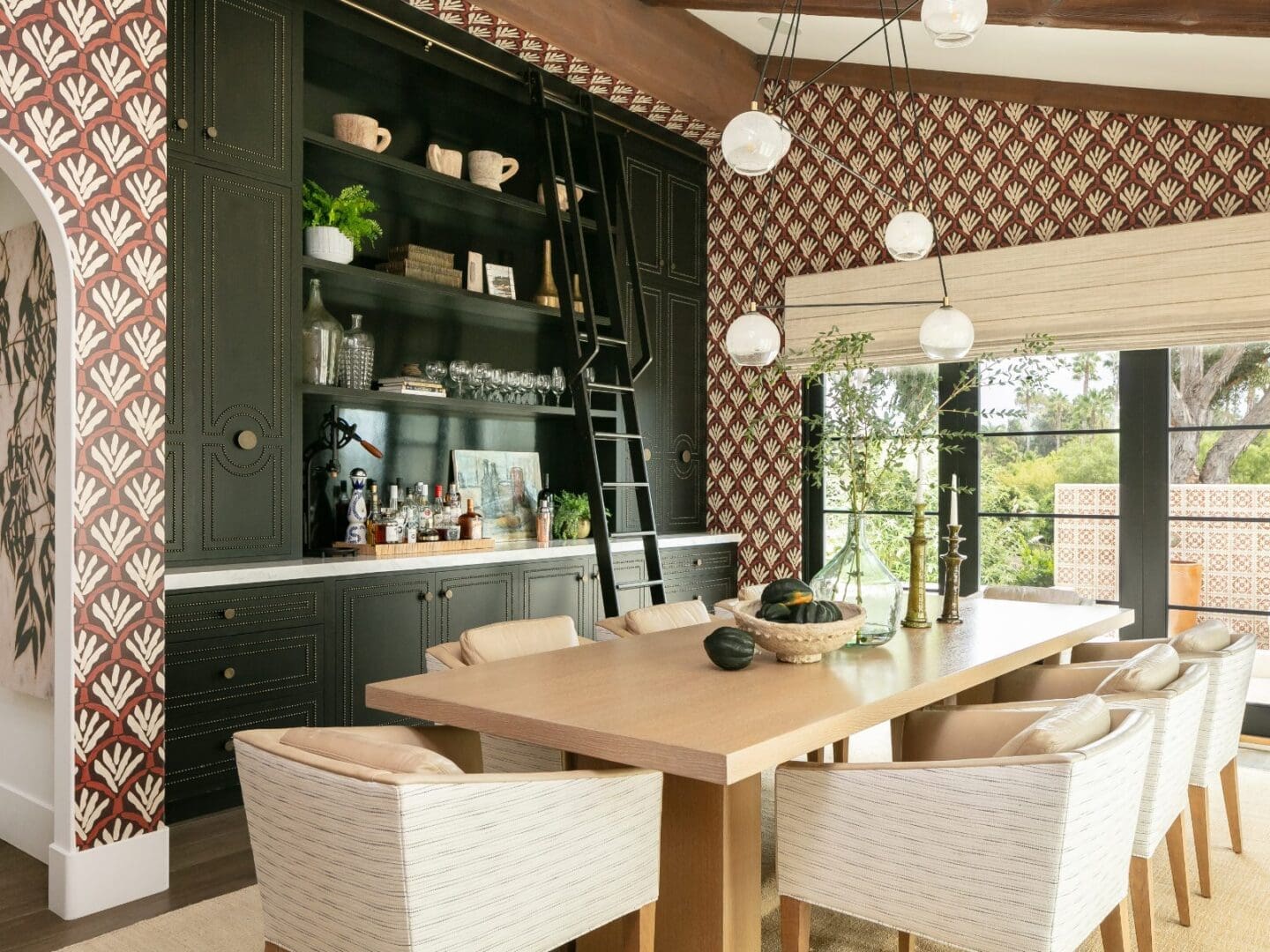 BLACKBAND-DESIGN-INTERIORS-RANCHO-SANTA-FE-ESTATE Dining room with patterned wallpaper and nail-stud cabinetry.