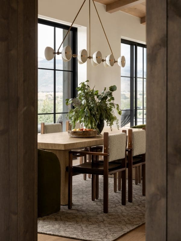 blackband-design-victory-ranch-utah-luxury-home A mountain home dining space seen through a wood walls doorway.