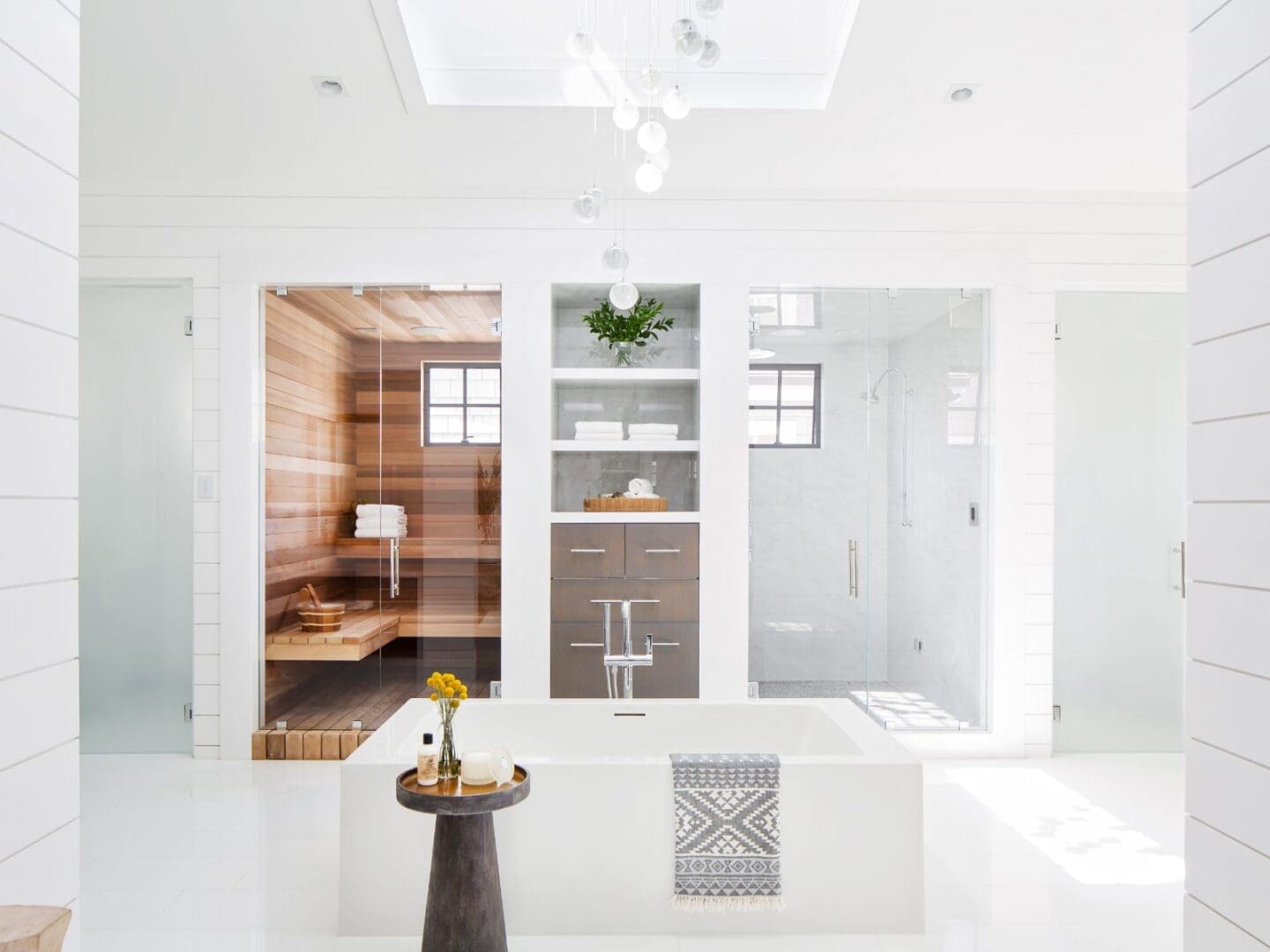Luxury white bathroom with sauna, steam shower, and soaking tub.