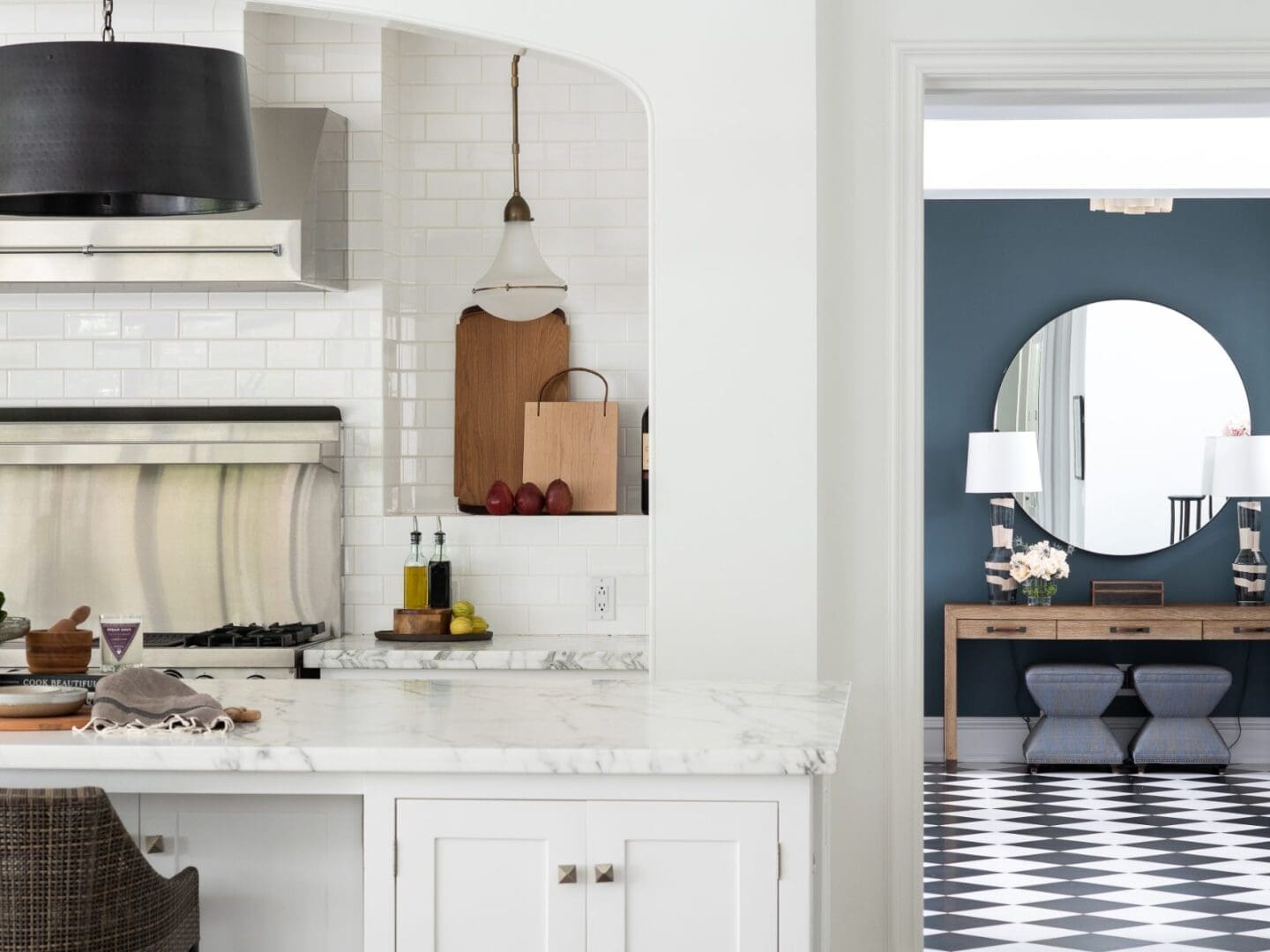 White kitchen with doorway view of a bold blue entry with black and white checkered floors.