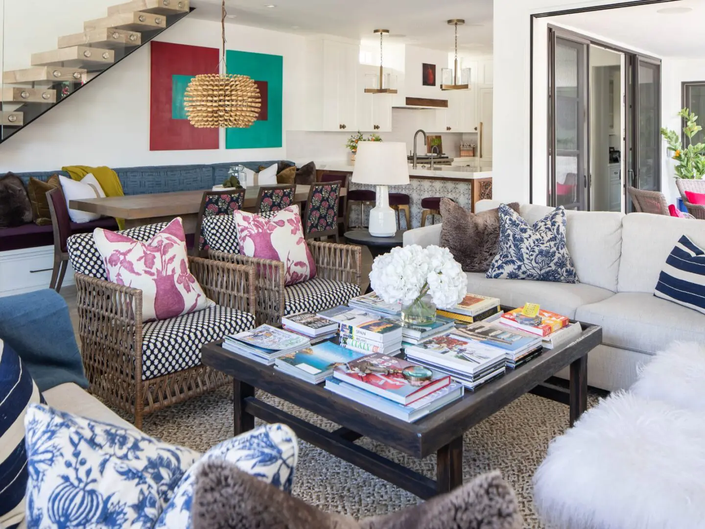 Eclectic living room design with books on coffee table and bright art on walls.
