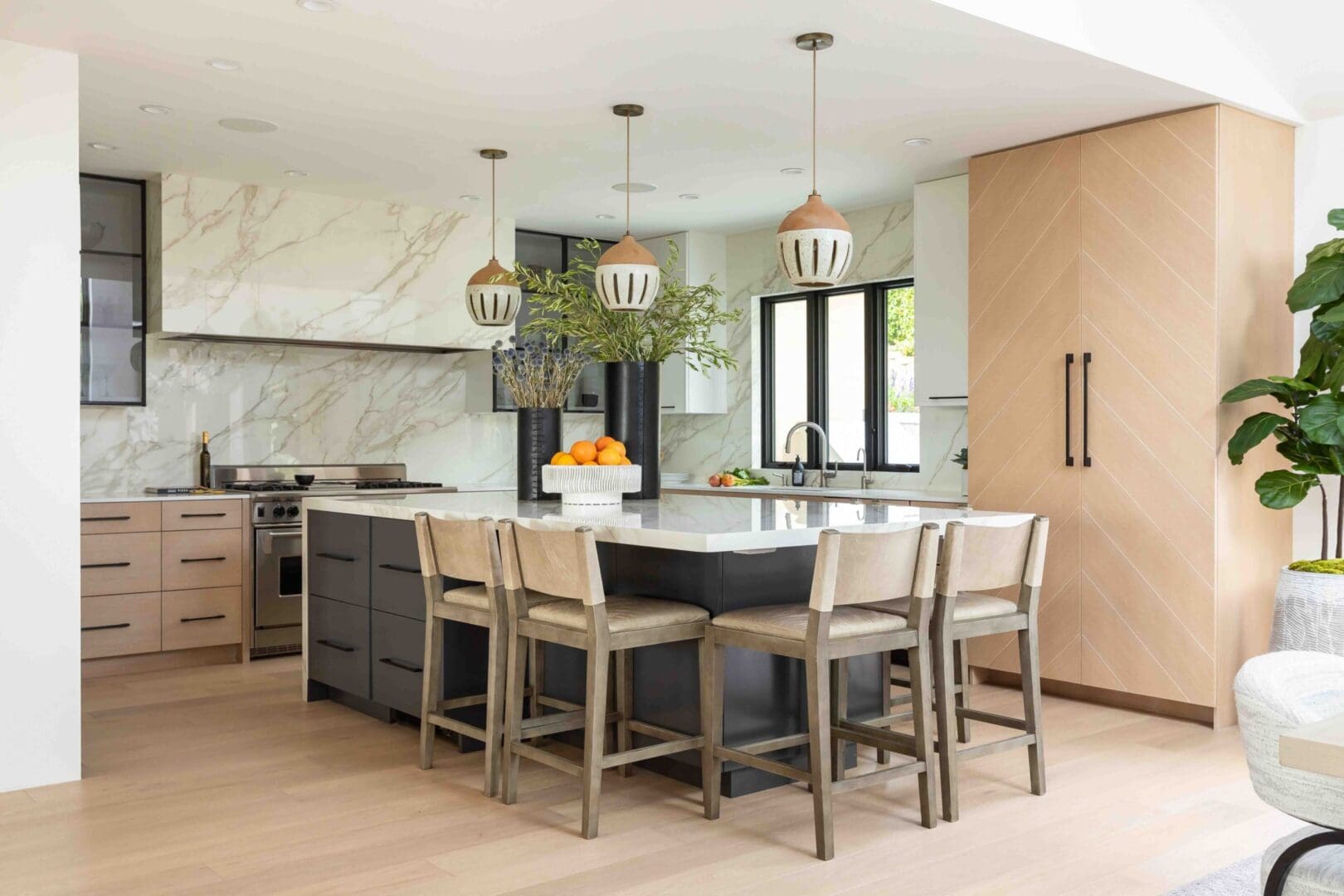 Coastal contemporary kitchen with blue island and vein slabs.