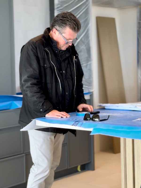 Blackband-Design-Greg-Onsite-Renovation Man reviewing plans at construction site.