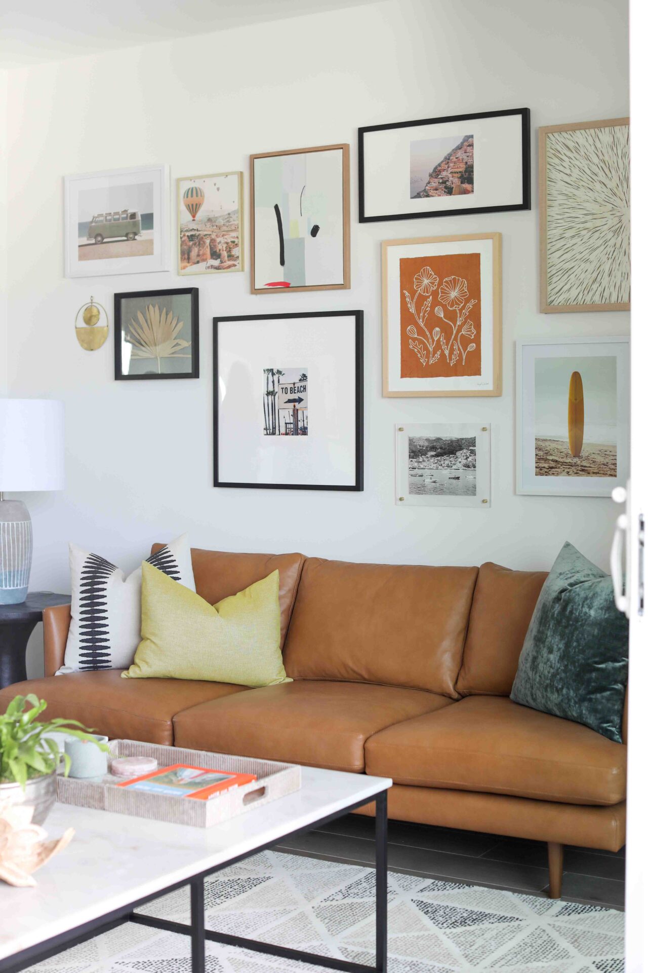 Blackband-Design-The-Isle-Mariner-Shores-1x-6 Gallery wall above brown leather couch.