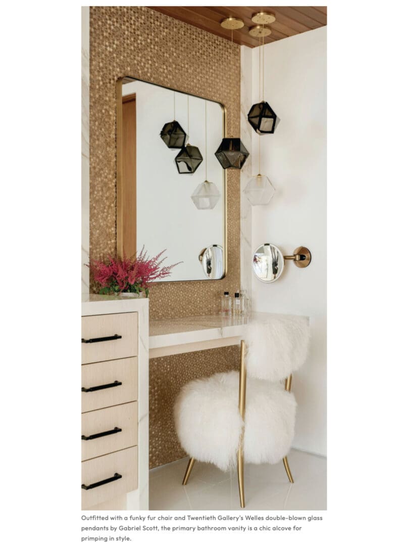 Bathroom corner with gold vanity setup and fluffy white chair.